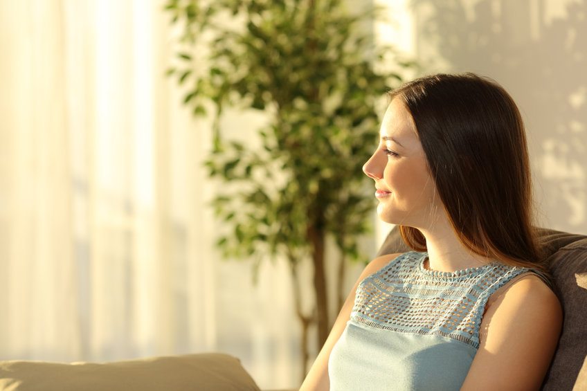 woman looking out window thinking